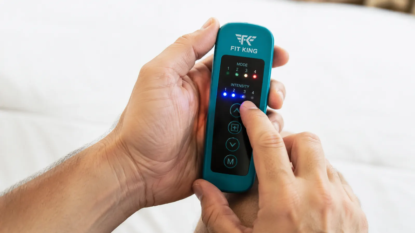 Close-up of the FIT KING handheld controller showing the button layout and intensity indicator lights