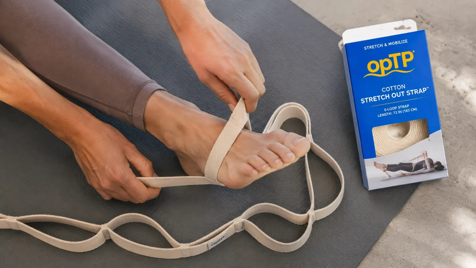 Close-up of hands threading a foot through one of the multiple loops on a cotton stretch strap