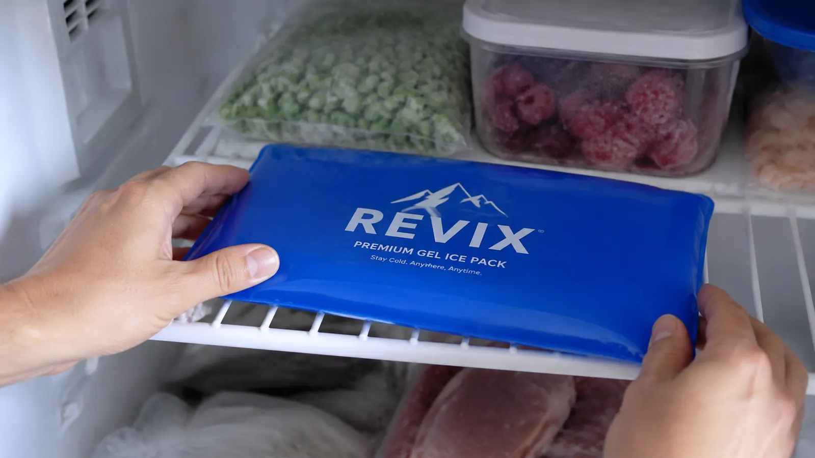 Close-up of REVIX ice pack being placed flat in a home freezer alongside other items
